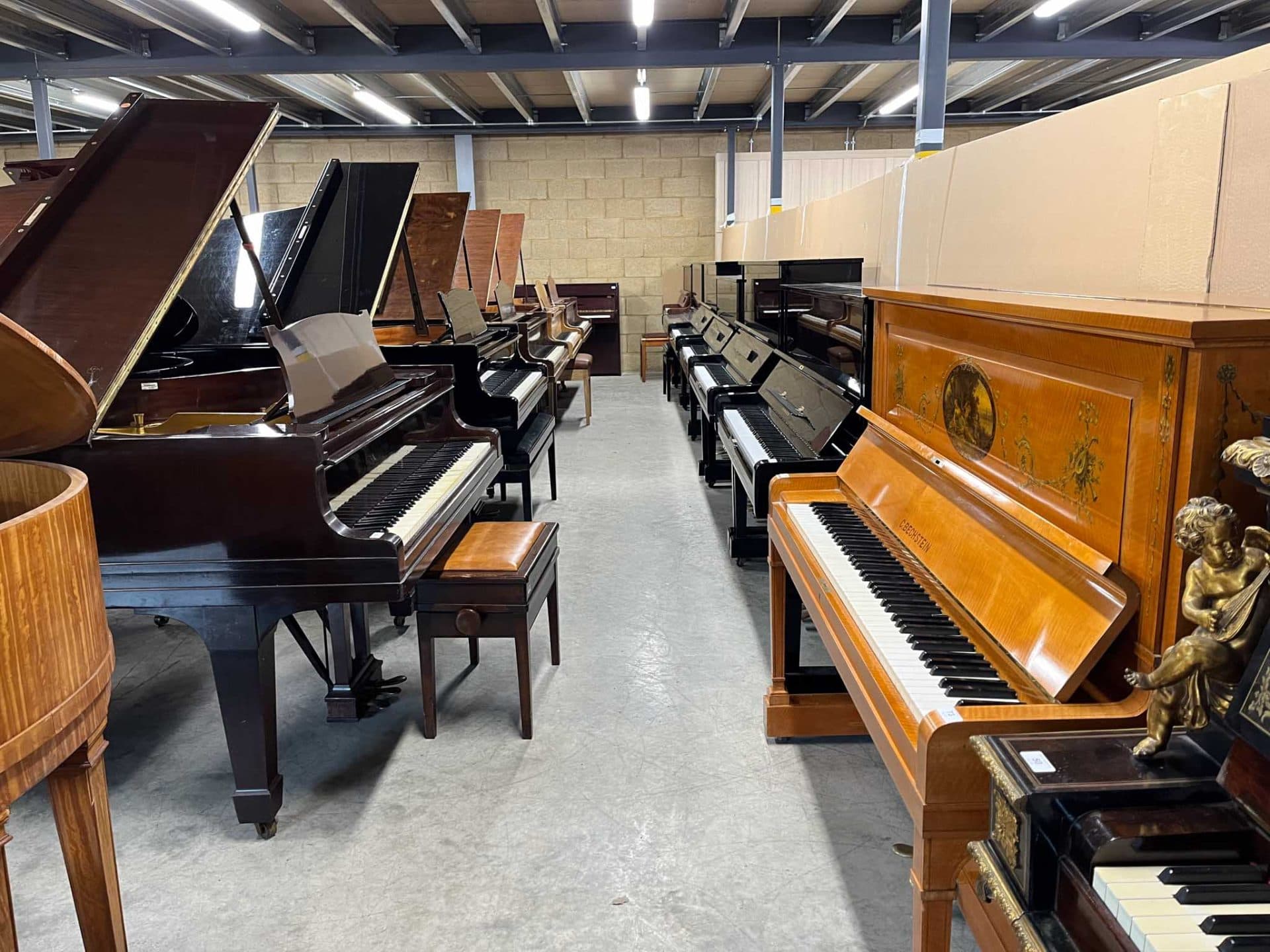 Vleugelpiano's opgesteld in het magazijn van Piano Auctions Ltd.